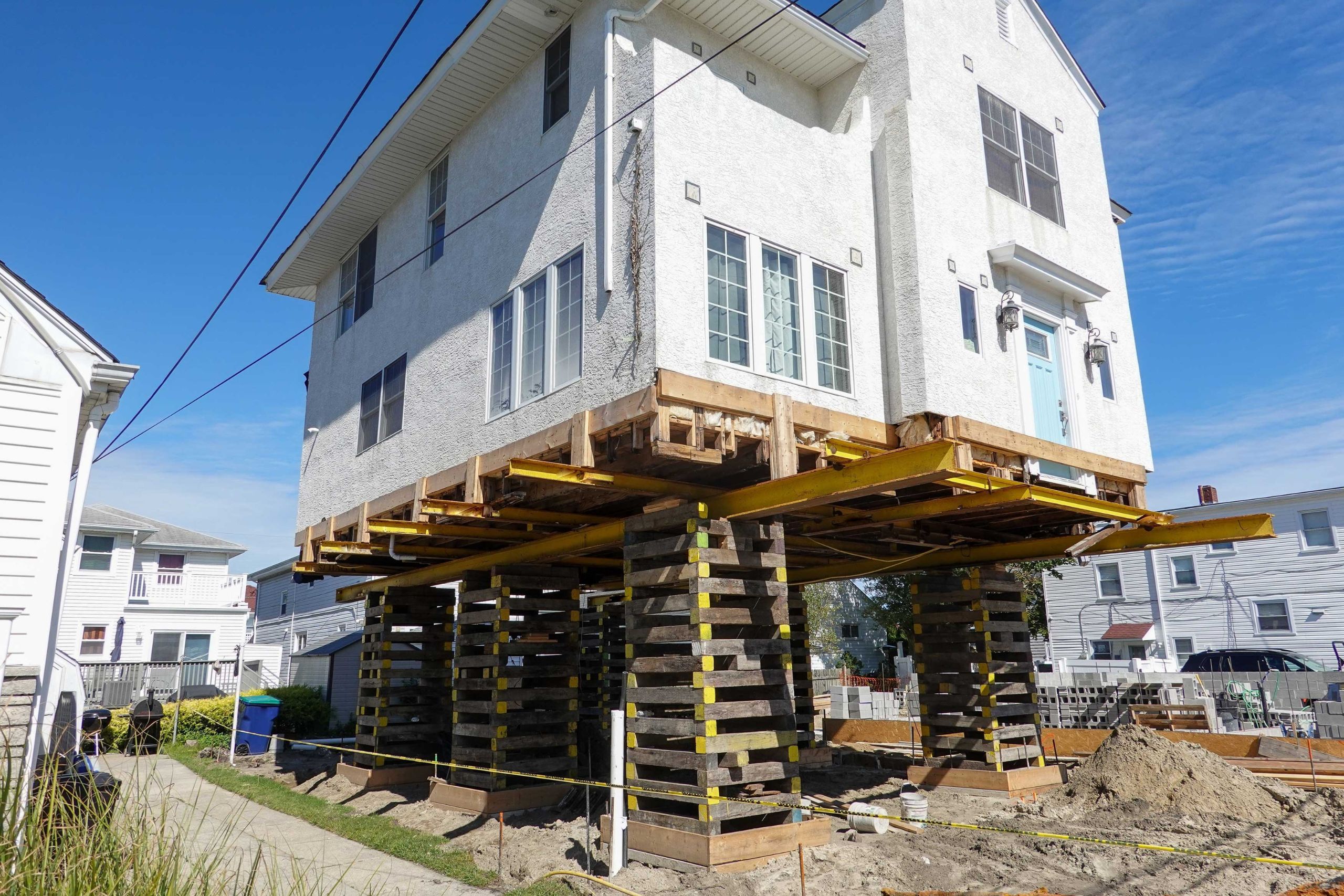 A team of professionals using specialized equipment to raise a house in Myrtle beach, preparing it for elevation and renovation